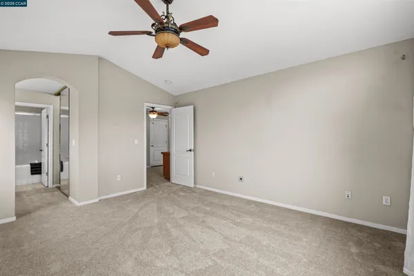 an empty room with chandelier fan