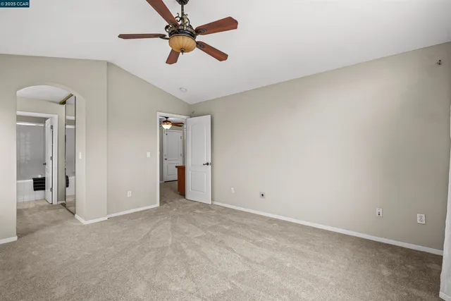 an empty room with chandelier fan