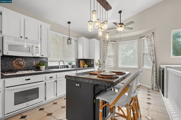 a kitchen with stainless steel appliances granite countertop a stove a sink and a refrigerator