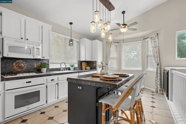 a kitchen with stainless steel appliances granite countertop a stove a sink and a refrigerator