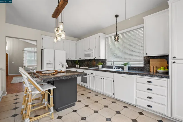 a kitchen with stainless steel appliances granite countertop a stove a sink and a refrigerator