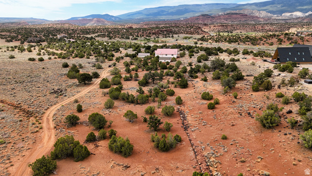 358 South Sky Drive Torrey, UT 84775 - Photo 53 of 82 Expansive desert landscape featuring red earth, scattered green foliage, distant mountains, and a clear sky