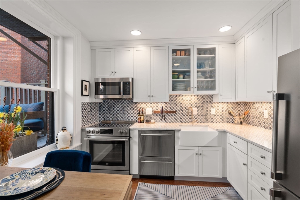 58 Temple Street, Unit 3 Boston, MA 02114 - Photo 7 of 17 a kitchen with granite countertop cabinets stainless steel appliances and a window