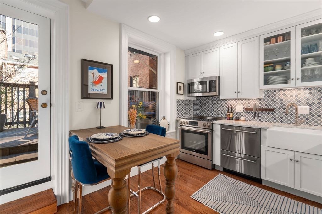 58 Temple Street, Unit 3 Boston, MA 02114 - Photo 8 of 17 a kitchen with stainless steel appliances granite countertop a stove top oven a sink a counter space and cabinets