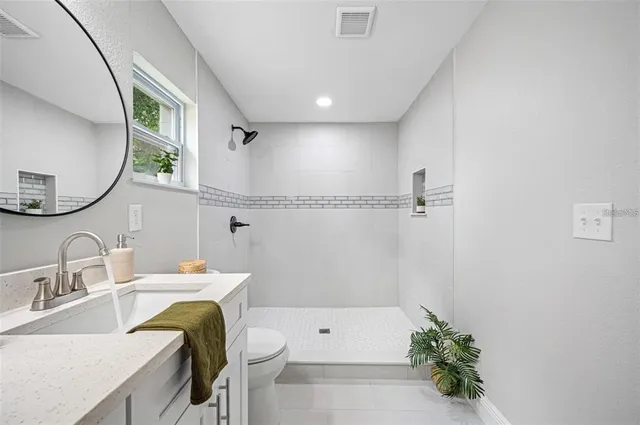a bathroom with a sink toilet and a mirror