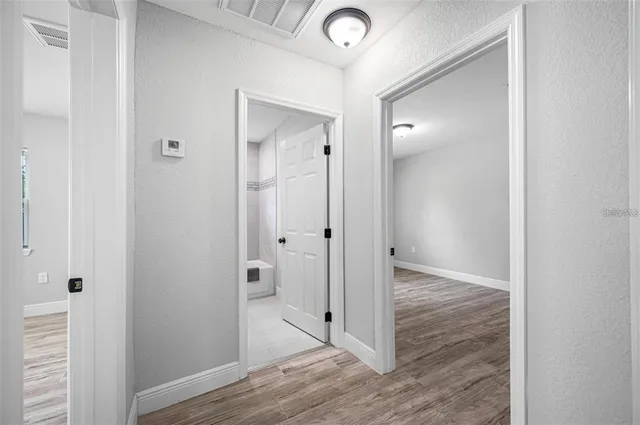 a view of a hallway with wooden floor