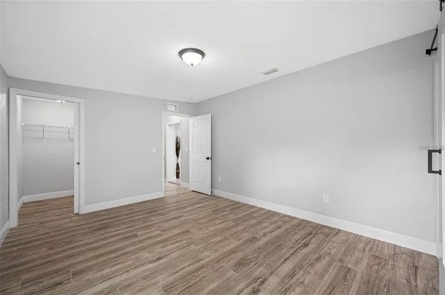 a view of an empty room with wooden floor