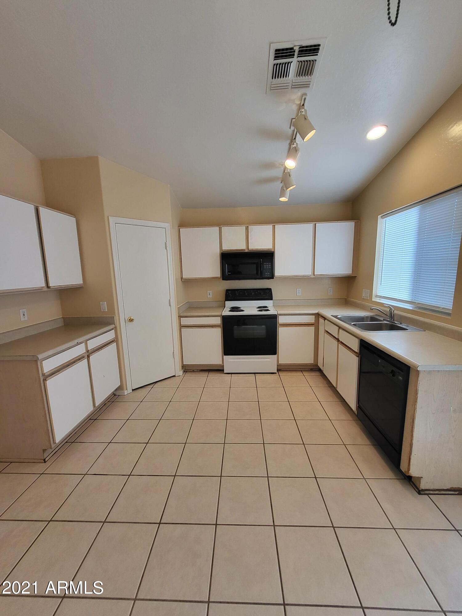 11929 West Larkspur Road El Mirage, AZ 85335 - Photo 4 of 12 a kitchen with stainless steel appliances granite countertop a refrigerator and a stove top oven