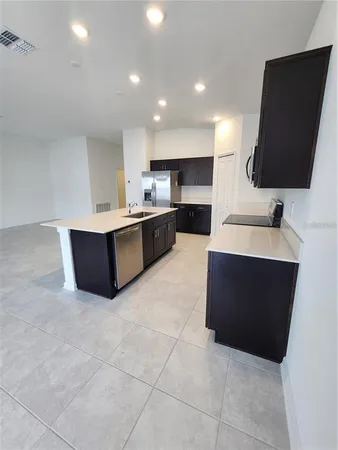 an empty room with furniture and a kitchen