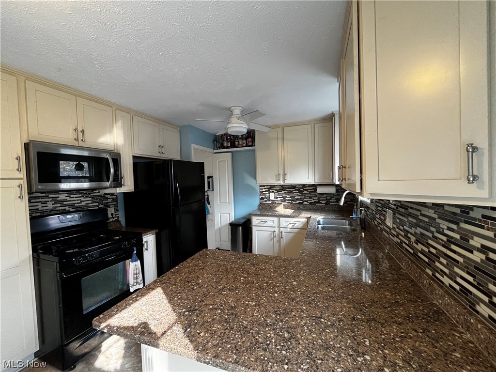 30824 Clarmont Road Willowick, OH 44095 - Photo 15 of 24 Kitchen featuring ceiling fan, tasteful backsplash, cream cabinets, and dark stone counters
