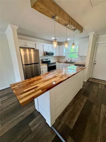 a kitchen with stainless steel appliances granite countertop a sink and a refrigerator