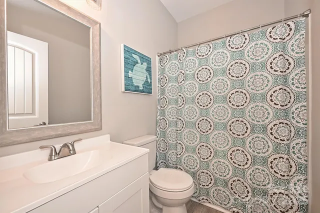 a bathroom with a toilet sink shower and mirror