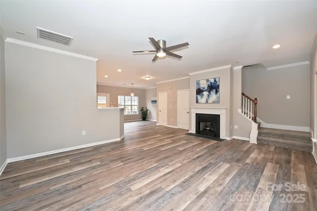 a view of a livingroom with a fireplace a ceiling fan and brick wall