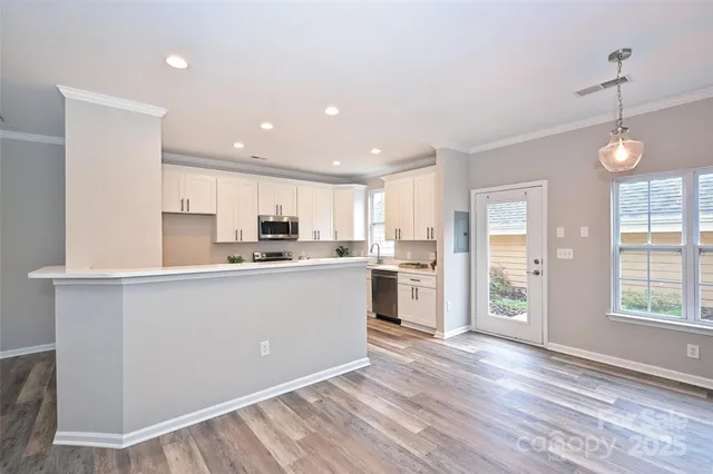 a kitchen with white cabinets and window