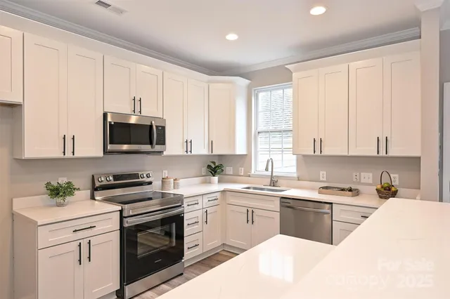 a kitchen with a sink white cabinets and white appliances