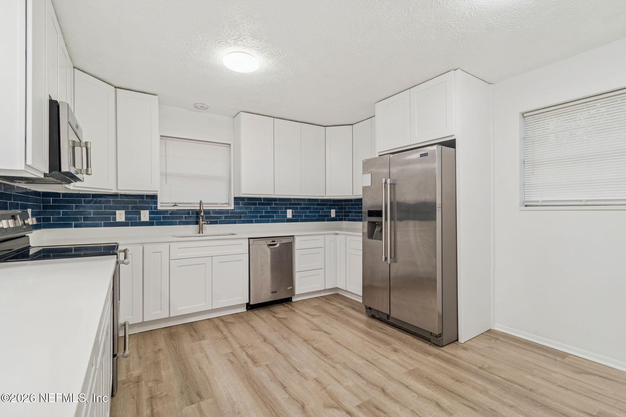 8234 Frost Street South Jacksonville, FL 32221 - Photo 23 of 65 a kitchen with a refrigerator a sink and cabinets