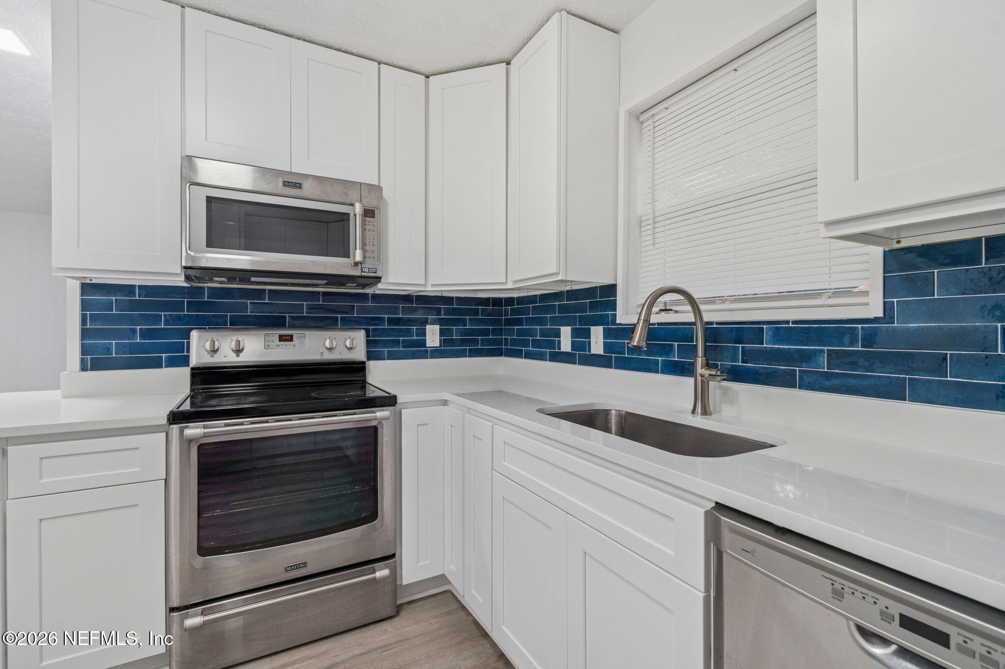 8234 Frost Street South Jacksonville, FL 32221 - Photo 35 of 65 a kitchen with stainless steel appliances granite countertop white cabinets a microwave oven and a sink
