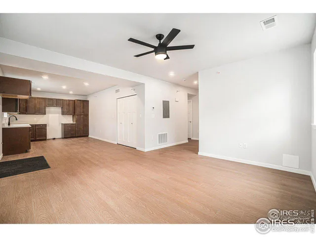 a view of a livingroom with a ceiling fan wooden floor and a ceiling fan