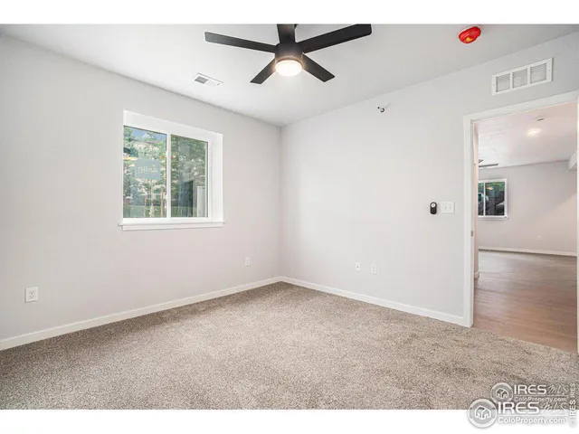 an empty room with fan and windows