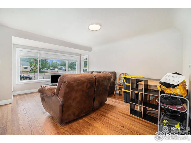 a living room with furniture a wooden floor and next to a window