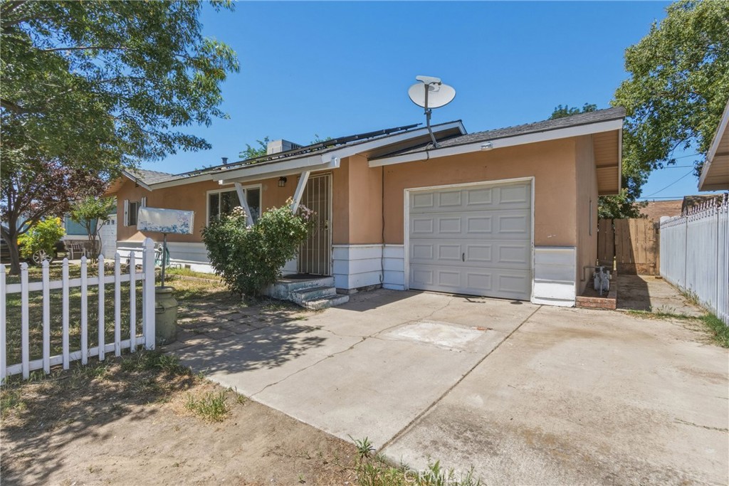 6812 Helton Street Winton, CA 95388 - Photo 3 of 24 a front view of a house with a yard and garage