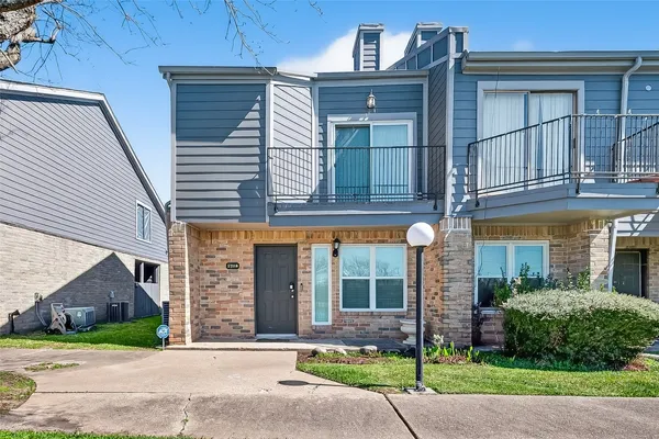 a view of a brick building with a tree in front of it