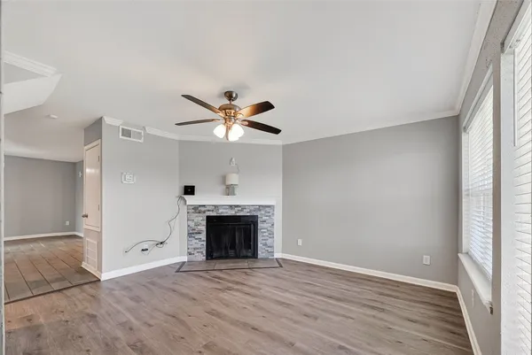 an empty room with windows fireplace and a sink