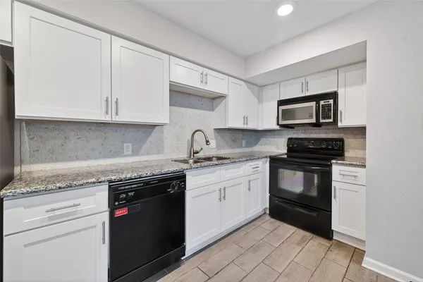 a kitchen with granite countertop a stove and a sink