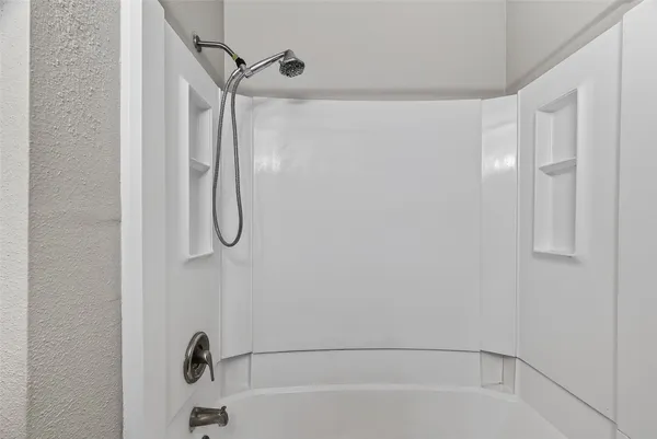 a bathroom with a bath tub with a shower