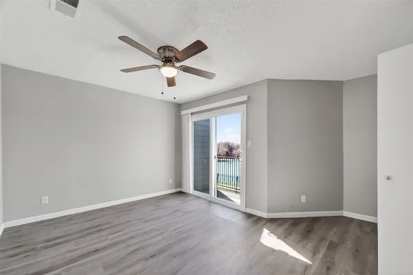 a view of a big room with wooden floor and windows