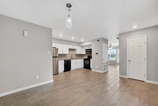 a view of a kitchen with a refrigerator a sink and dishwasher a refrigerator with wooden floor