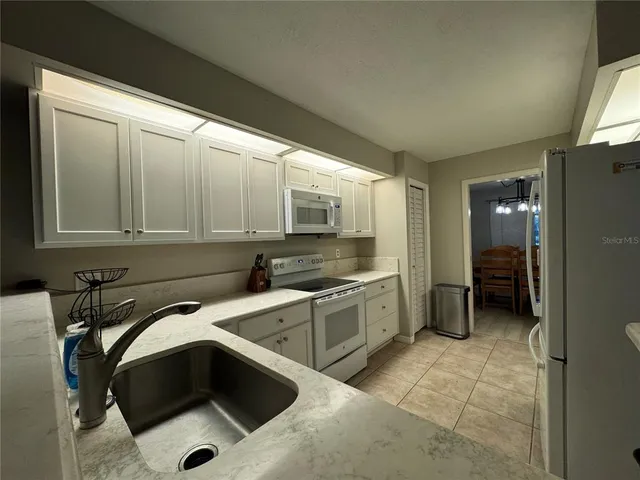 a kitchen with a sink a stove and cabinets