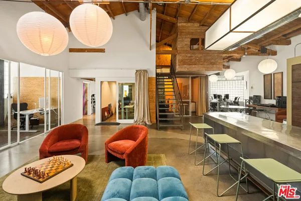 a living room with furniture a rug and a floor to ceiling window