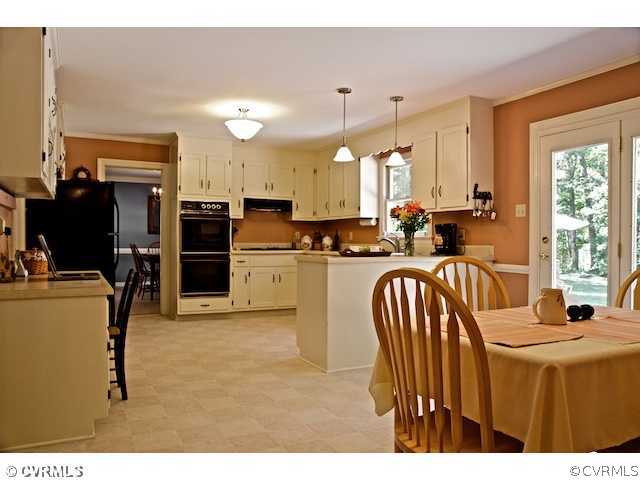 10800 Shingle Oak Road Chester, VA 23831 - Photo 4 of 11 a kitchen with sink refrigerator and cabinets