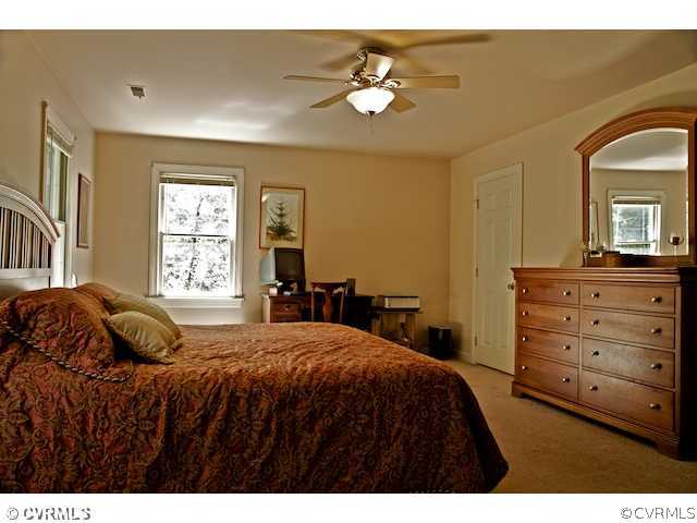 10800 Shingle Oak Road Chester, VA 23831 - Photo 8 of 11 a bedroom with a bed and a chandelier