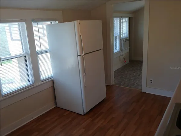a view of a kitchen with wooden floor and electronic appliances