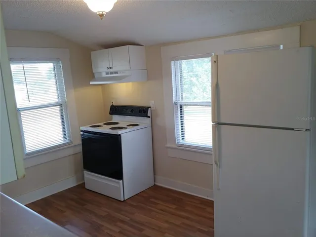 a kitchen with stainless steel appliances granite countertop a stove a sink and a window
