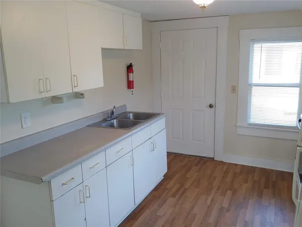 a hallway with white cabinets and sink