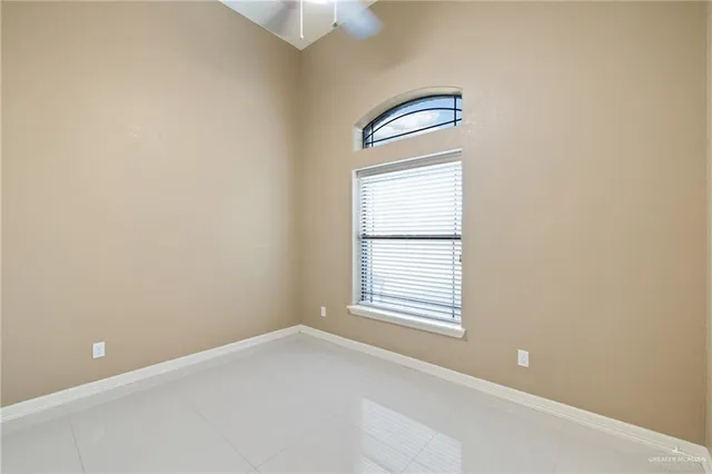an empty room with windows and ceiling fan