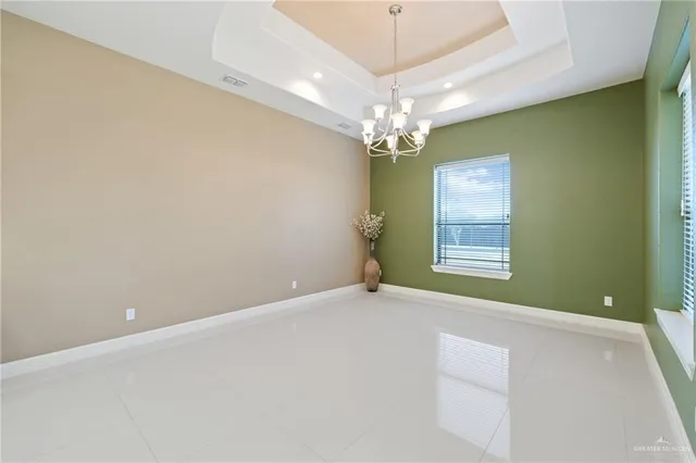 en empty room with windows and chandelier fan