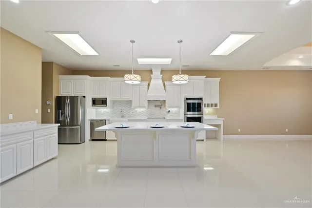 a large kitchen with a large counter top appliances and cabinets