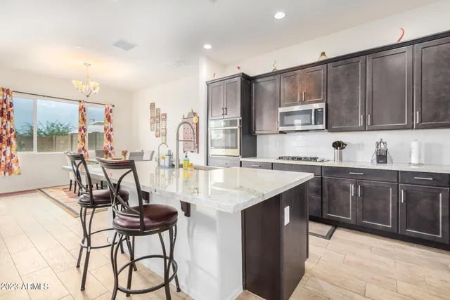 a kitchen with stainless steel appliances kitchen island granite countertop a sink and cabinets