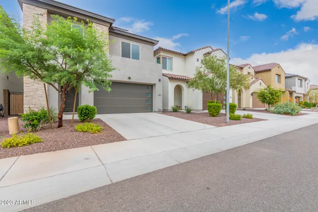a front view of a house with garden and parking