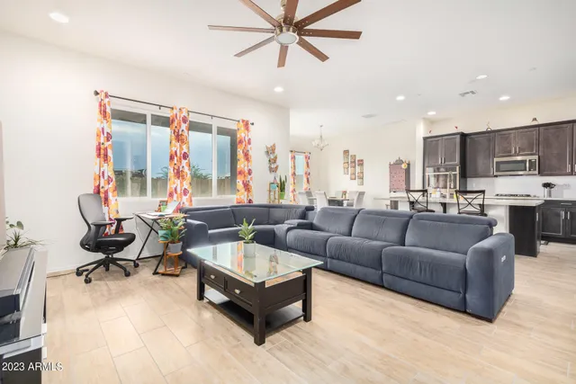 a living room with furniture and a view of kitchen