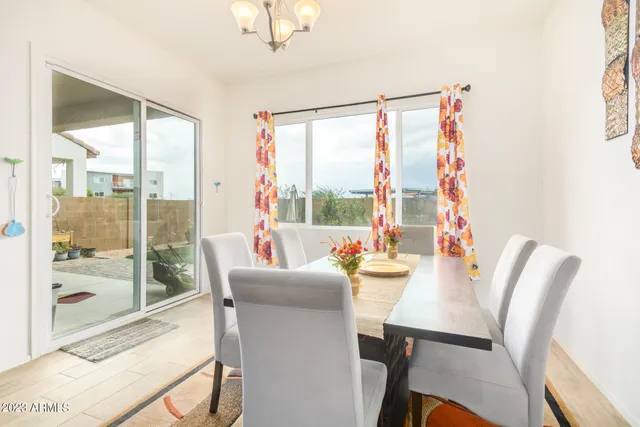 a dining room with furniture a chandelier and wooden floor