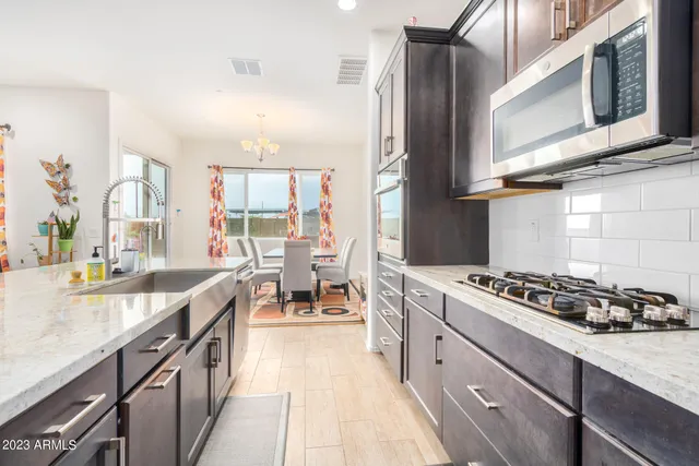 a kitchen with stainless steel appliances a stove a sink dishwasher and cabinets with wooden floor