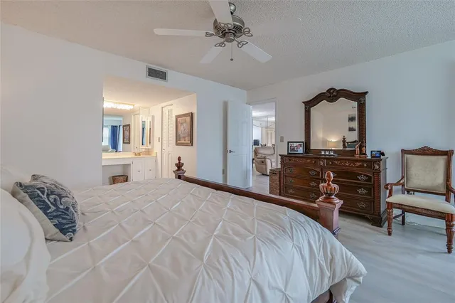 a bedroom with a bed a chandelier and dresser