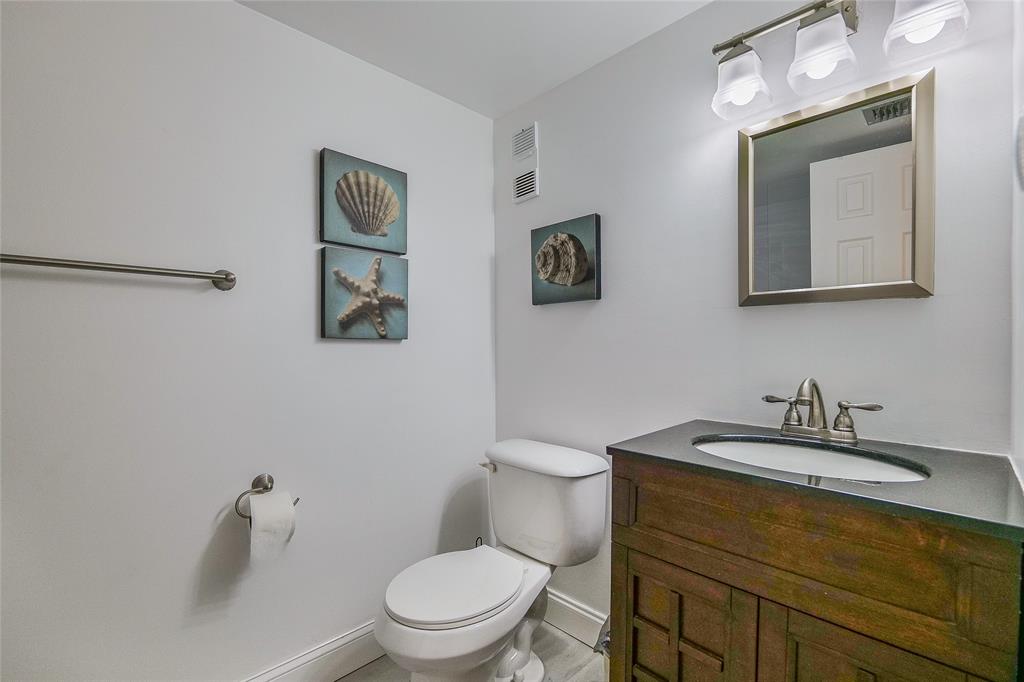 3930 Inverrary Boulevard, Unit 407D Lauderhill, FL 33319 - Photo 20 of 60 a bathroom with a toilet a sink and mirror