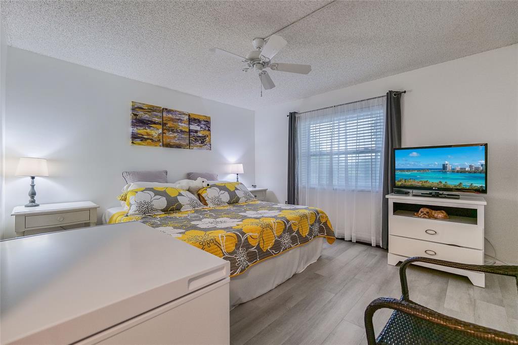 3930 Inverrary Boulevard, Unit 407D Lauderhill, FL 33319 - Photo 24 of 60 a bedroom with a bed and a flat screen tv