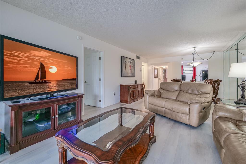 3930 Inverrary Boulevard, Unit 407D Lauderhill, FL 33319 - Photo 7 of 60 a living room with furniture and a flat screen tv